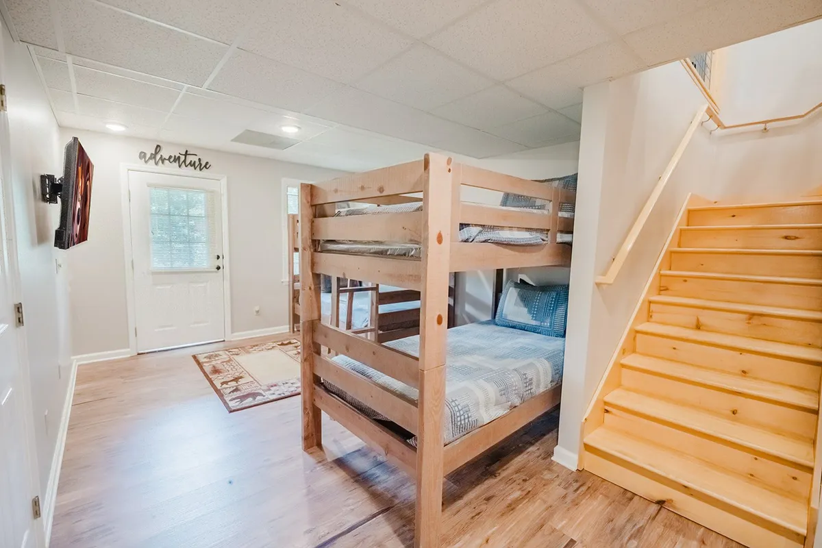 A playful sleeping nook featuring twin/twin bunk beds, a nearby TV, and a relaxed, cheerful atmosphere. The arrangement invites both sleep and play, making it ideal for children or extra guests.