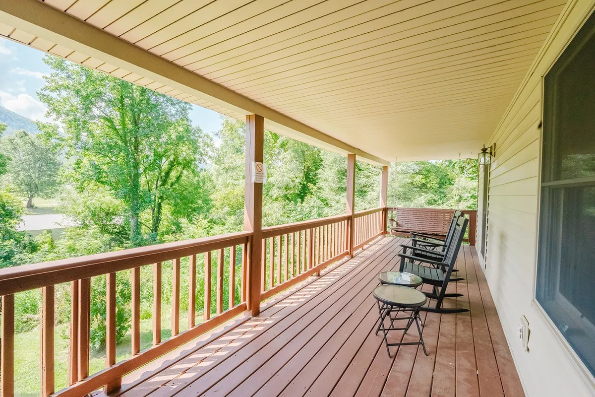 A peaceful porch outfitted with rocking chairs overlooks lush greenery, inviting guests to unwind, enjoy morning coffee, or reflect after busy days out exploring nearby attractions.